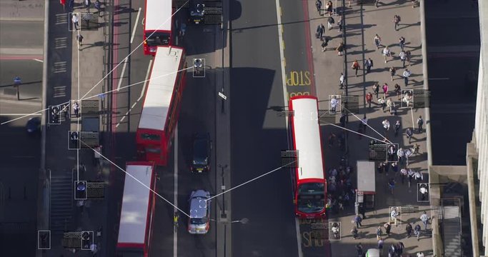 Aerial view of commuters walking on London Bridge. Facial recognition interface showing personal data for each person. Surveillance concept. Artificial intelligence. Deep learning. Traffic. England.