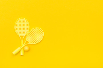 Tennis racket and ball sports on yellow background.