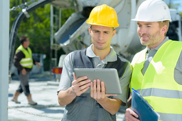 workers on outdoor site looking at tablet