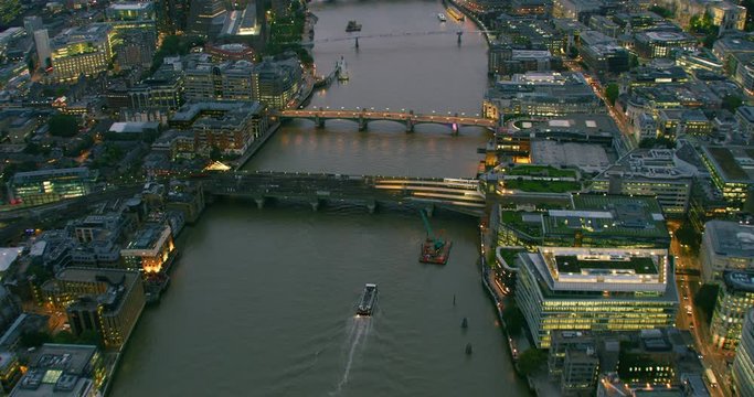Aerial view of traffic passing by London famous bridges over River Thames. Several ships sailing the river and bridges full of people. England. UK. Shot on Red Weapon 8K.