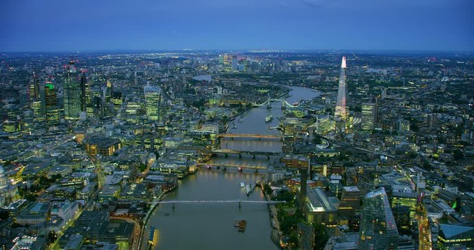 Aerial view of London famous landmarks. Traffic passing by London famous bridges over Thames River. Several ships sailing the river and bridges full of people. England. UK. Shot on Red Weapon 8K.