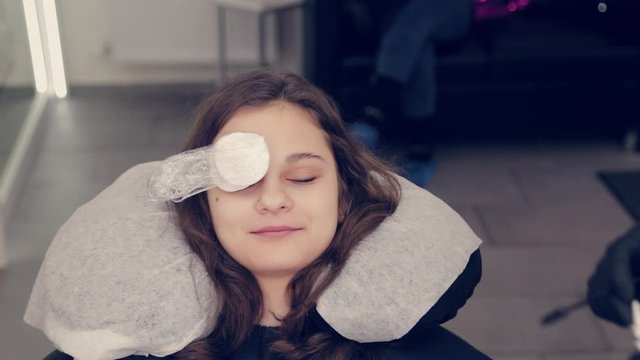 Professional woman eyebrow master puts film on eyebrows in a beauty salon.