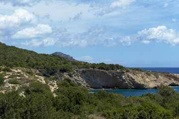 Rocky sea coast with clean blue water, cloudy sky and city view. Ibiza island, Spain © Viacheslav Alferov