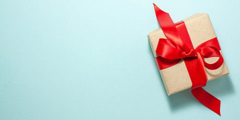 Banner of brown paper gift box with a red satin ribbon bow flat lay