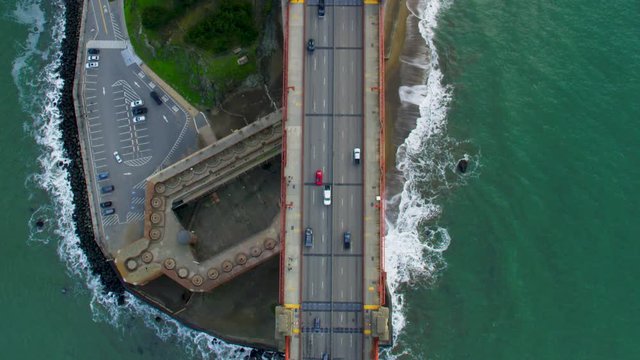 Traffic passing by the Golden Gate Bridge. San Francisco, US. Aerial view. It connects the San Francisco peninsula to Marin County. US route 101 and SR1 full of cars. Shot on Red weapon 8K.