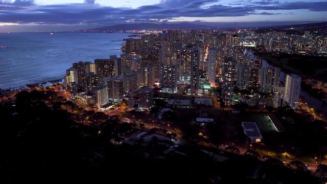Honolulu skyline. Aerial view of Waikiki beach,  Ala Wai canal and Kapi olani Regional Park. Oahu is the third largest Hawaiian island. United States. Dusk.