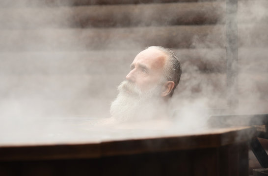 Bearded senior man enjoying thermal bath in thalassotherapy center.