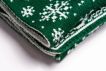 fragment of folded green scarf with snowflakes