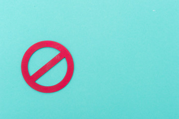 Red forbidden sign on pastel green background.