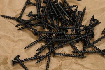 black tapping screws on the kraft paper, close up
