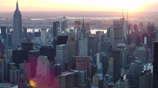 Aerial view of Manhattan skyline and cityscape. Iconic skyscrapers. Sunset in New York City, United States. Shot from a helicopter.