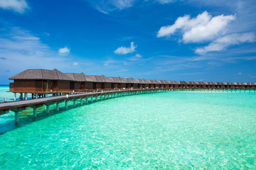 Maldives water bungalows resort at islands beach. Indian Ocean, Maldives. Beautiful sea landscape, luxury resort and  sky. Beach  under wonderful sky
