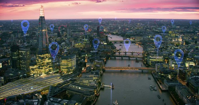 Localization icons over London. Aerial view of a smart and futuristic city. Skyscrapers in the financial district. Perfect to illustrate technological concepts as: data communication, AI, GPS, IOT. 