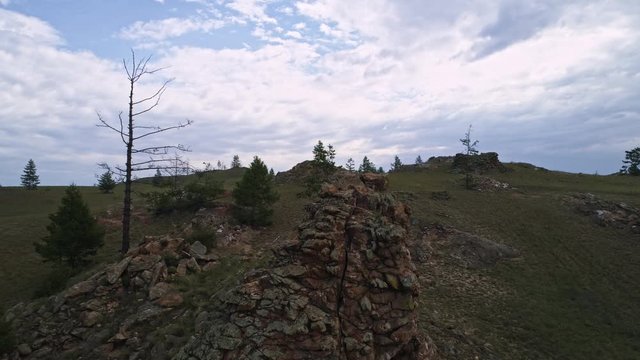 Baikal Valley spirits,Tazheran steppe, stone cliffs on the road. Aerial Summer