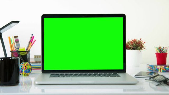 Laptop with colorful office elements. Dolly in. Chroma Key. Perfect to put your own images or videos. Track with perspective corner pin.   