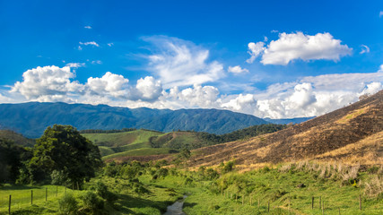 Beauty In Nature Summer Landscape. Amazing Blue Sky With Beautiful Clouds, Mountains, Meadow With Green Grass, Burned Field. Aerial Rural View In Rio de Janeiro District. Brazilian Countryside.
