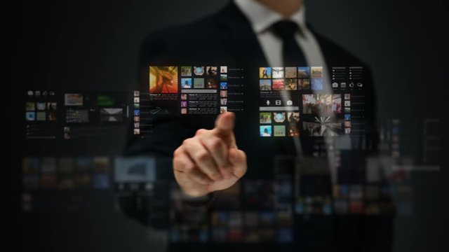 Businessman working on a futuristic holographic interface. Video wall. 