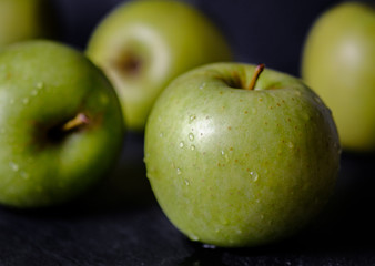 Green apple, fresh and wet isolated on black background