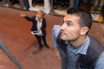 female manger pointing at worker in a factory