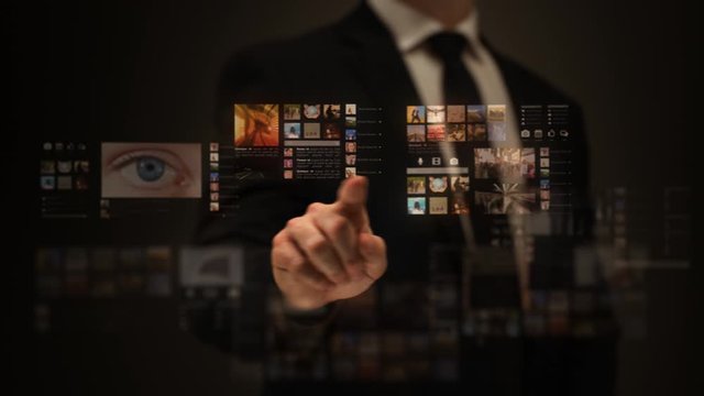 Businessman working on a futuristic holographic interface. Touchscreen. Travel from an eye to a galaxy. 