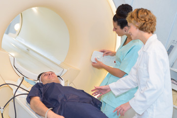 nurses reassuring patient as he enters mri scanner