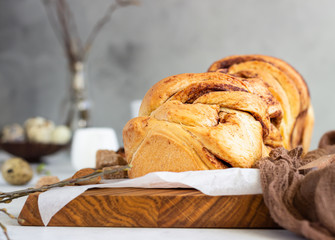Cinnamon babka or swirl brioche bread. Cinnamon roll bread. Povitica: traditional Polish sweet bread. Homemade pastry for breakfast. Light grey background.