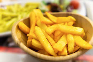 french fries with spice sauce in wooden bowl
