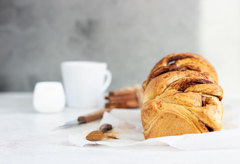 Cinnamon babka or swirl brioche bread. Cinnamon roll bread. Povitica: traditional Polish sweet bread. Homemade pastry for breakfast. Light grey background.