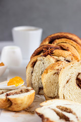 Slices of homemade cinnamon babka or swirl brioche bread. Cinnamon roll bread. Povitica: traditional Polish sweet bread. Light grey background.
