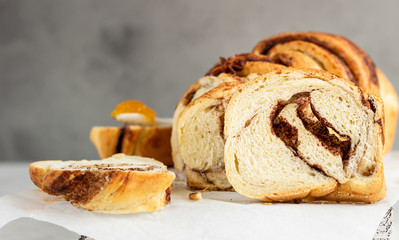 Slices of homemade cinnamon babka or swirl brioche bread. Cinnamon roll bread. Povitica: traditional Polish sweet bread. Light grey background.