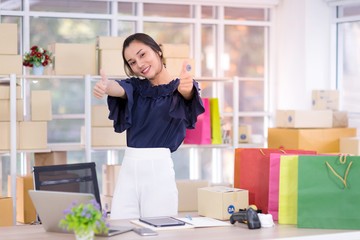 Asian young women happy after new order from customer.  Smile and looking at laptop. Online shopping SME entrepreneur or freelance working concept.