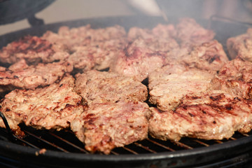 Grilled pork steaks on a round grill