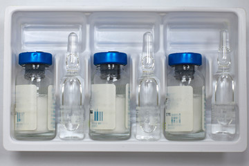 Antibiotics in glass jars with vials on a white background