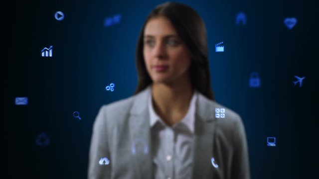 Businesswoman working on holographic interface. Financial. Multicolored. Woman touching a visual screen with holographic computer icons. Financial diagrams appearing. More colors in my portfolio.  