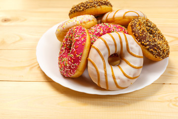 Glazed donuts in a plate on the background Board