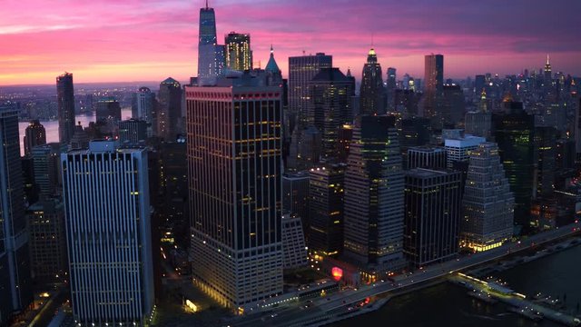 Aerial view above the East River. Famous Manhattan skyscrapers. Traffic passing by FDR Drive. Manhattan. United States, North America. Dusk. Shot from a helicopter.
