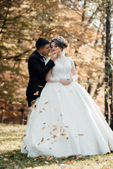 Beautiful bride with modern bouquet pose with stylish groom in autumn park. Sensual romantic moment. Wedding. Stylish and beautiful.