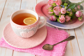 Fototapeta na wymiar Cup with hot tea in knitted clothes with pink heart. Valentine's day concept