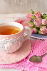 Cup of tea with pink rose and silver spoon. . Vertical image, romantic concept