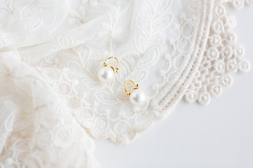 Obraz na płótnie Canvas White pearl vintage style earring on lace 