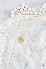 Gold pendant necklace on lace