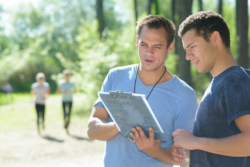 sports instructor talking with male sportsman outdoors