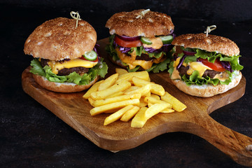 Tasty fresh meat burgers with salad and cheese and french fries. Homemade angus burger.