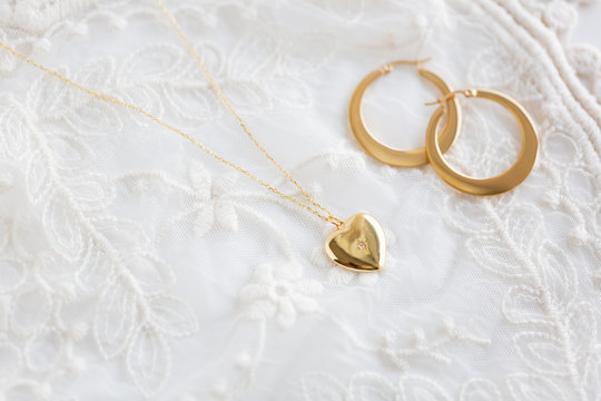 Gold Heart Necklace And Gold Hoop Earrings On Lace