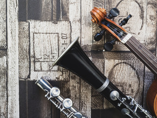 Klarinette, Flöte und Geige liegen auf einem Stück Stoff
