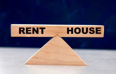 the concept of the balance between rent and a house on wooden scales