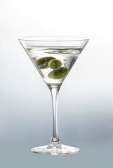 Olive berry falling in a glass with white wine