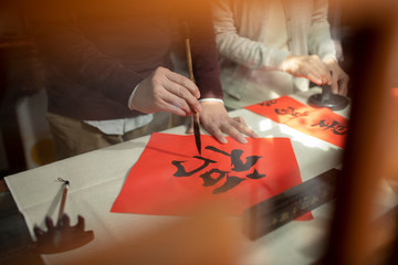 Senior couple writing calligraphy on couplets