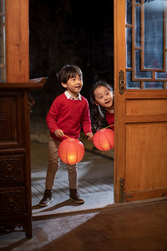 Happy sibling holding Chinese lanterns