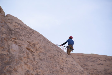 man climbing on top of rock